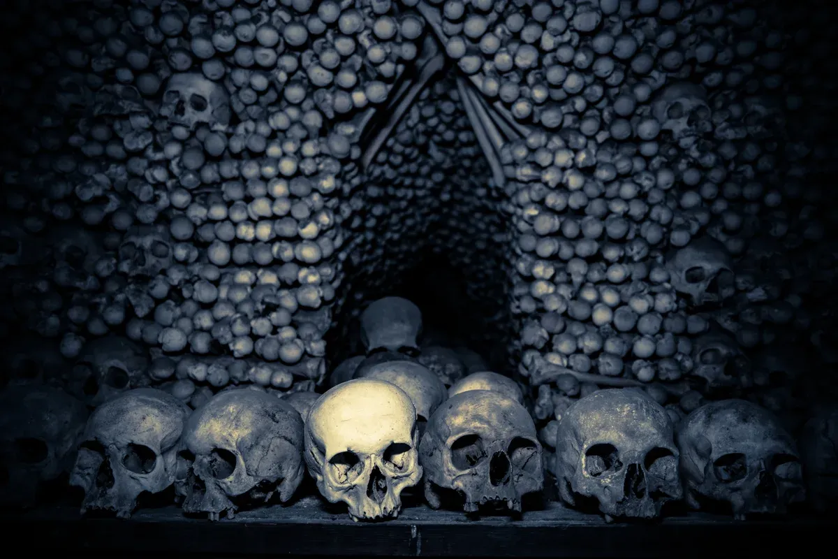 Stacked skulls in the Sedlec Ossuary on a Kutná Hora bone church tour from Prague