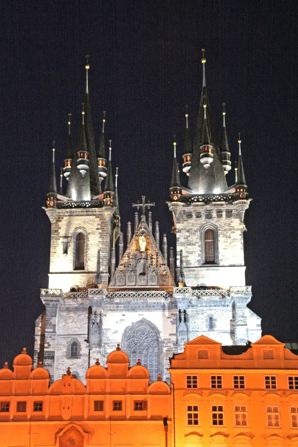 Týn Church lit at night above Old Town Square, where most ghost tours in Prague begin